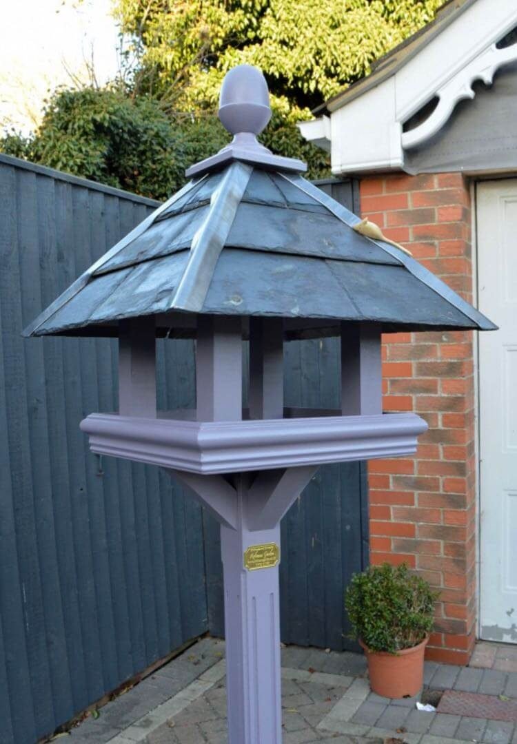 Bespoke bird table design with a slate roof hand painted in Lincolnshire, England, UK using Farrow & Ball exterior eggshell paint. Uniquely crafted using sustainable FSC certified timber / wood. This bird table and feeder is anti squirrel that doesn’t require anchoring pegs or to be attached to a fence. The bird table design is different to Argos, B&M, ALDI, homebase, dobbies, gardman, home bargains, pets at home, B&Q, b & q, M&S, Robert dyas, rspb, ikea, john lewis, QVC or any other garden centre. We are an online only store and we are not on the high street. We also have outlet shops across etsy and ebay UK. Our design plan, dimensions and height are suitable for small birds and is freestanding and a perfect bird table gift. Hooks provided to allow bird feeders to be hung from the bespoke bird feeders and table. Visit out gallery to see all the bird table images. Other options include bird table on pole or bird table on spike. Willow bird table on a tree stump option. Bird table / bird feeder delivered ready assembled. Perfect bird table for your garden.